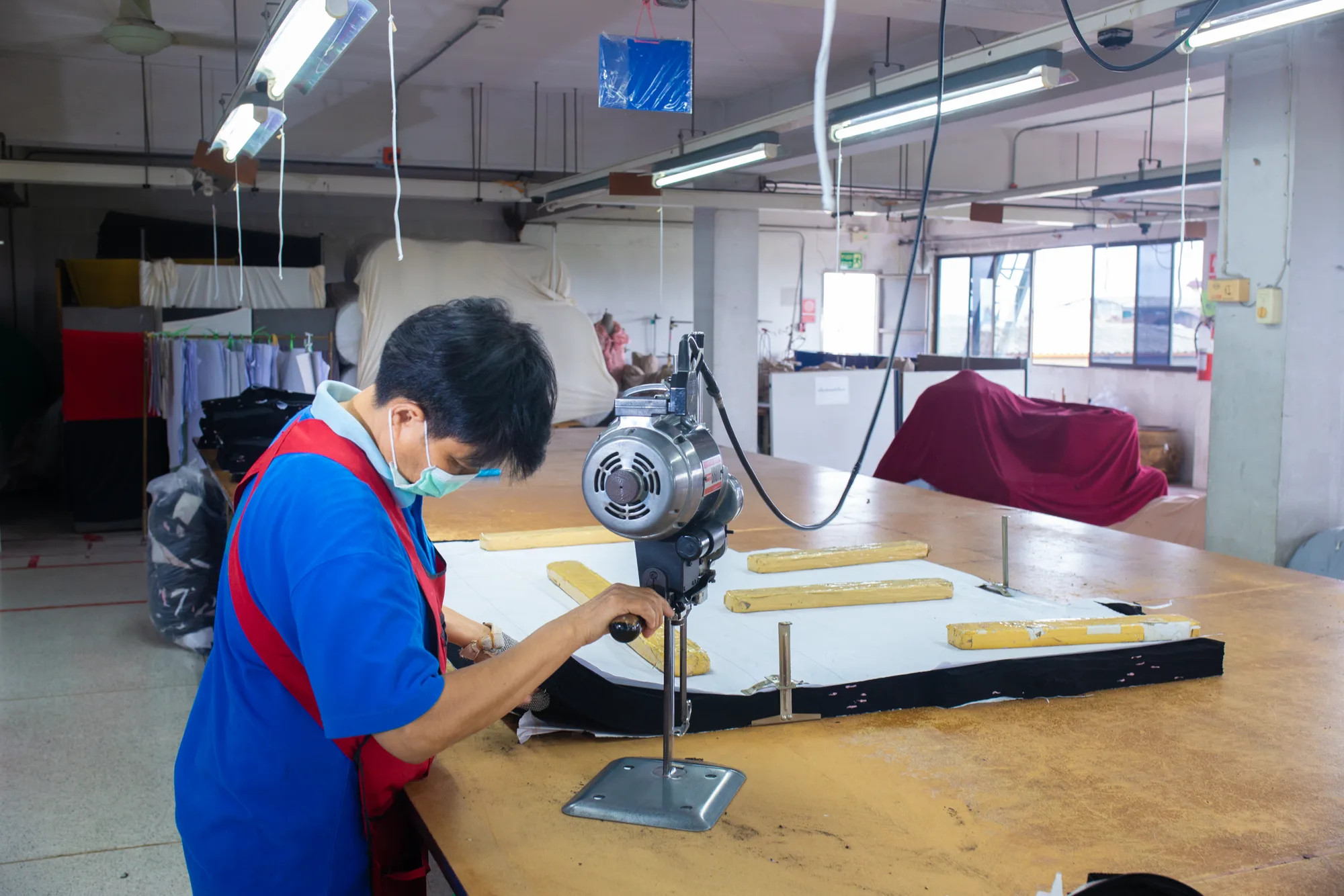 พนักงานตัดผ้าในขั้นตอนเตรียมชิ้นงานก่อนการเย็บ