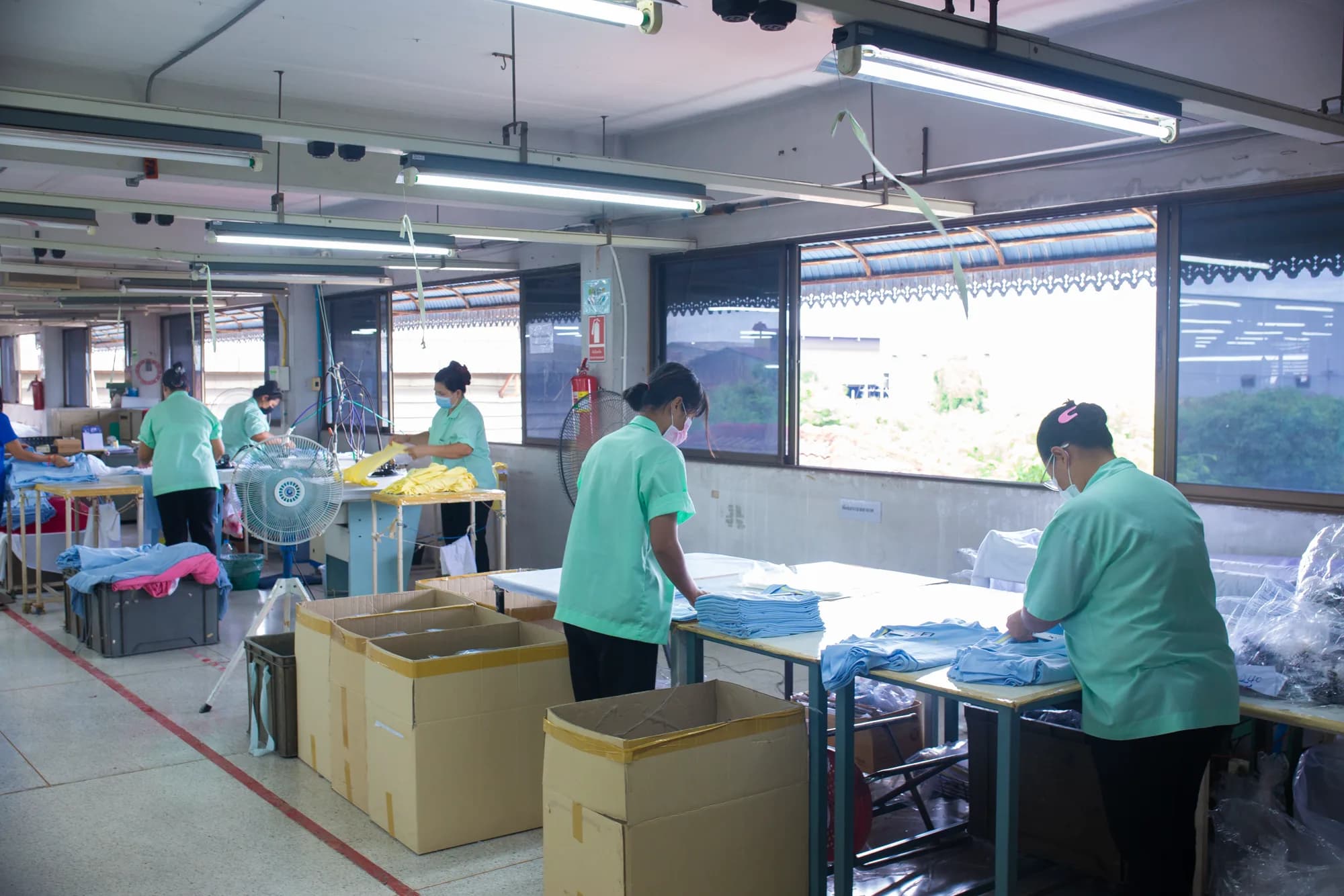 พนักงานทำงานในสายการตัดเย็บภายในโรงงาน
